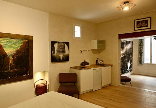 une pièce avec une cuisine et un salon dans l'établissement Suite dans maison d'artiste, à LʼIsle-sur-la-Sorgue