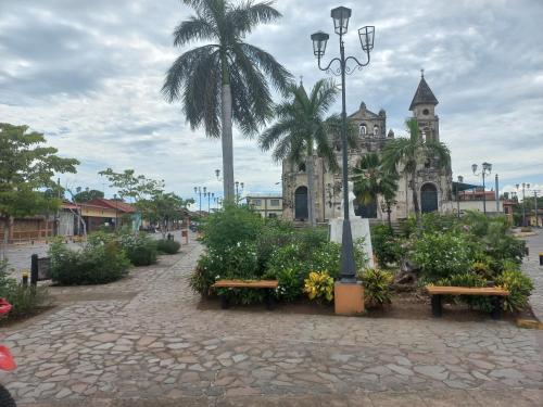 a building with benches and a palm tree and a church at Charming Home on La Calzada in Granada
