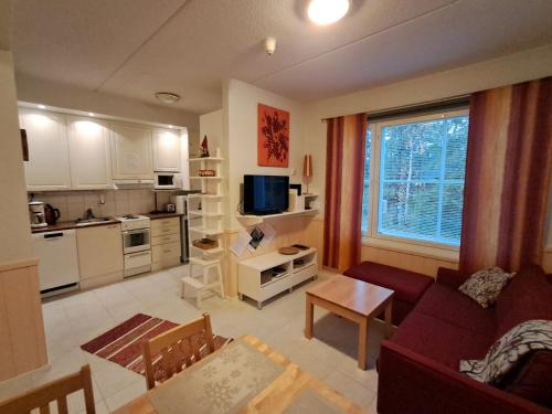 a living room with a couch and a kitchen at RöhköStar 108 in Äkäslompolo