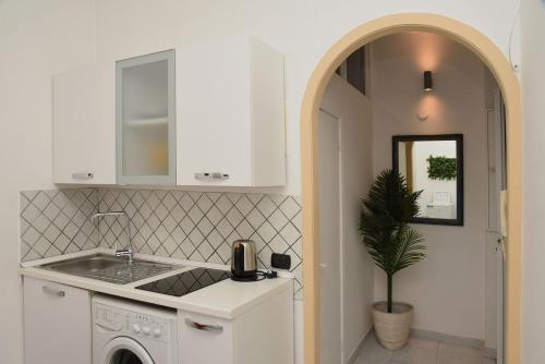 a kitchen with a sink and a washing machine at Incoming Quartieri Spagnoli in Naples