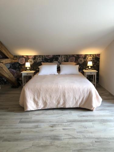 Gîte Chez Marcel & Marthe في Saint-Front-la-Rivière: غرفة نوم مع سرير وطاولتين مع مصابيح