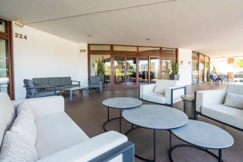 a lobby with white couches and tables and chairs at Holiday Inn Porto Gaia by IHG in Vila Nova de Gaia