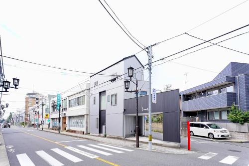 an empty street with a white car parked on the street at LOISIR Kunitachi in Kunitachi