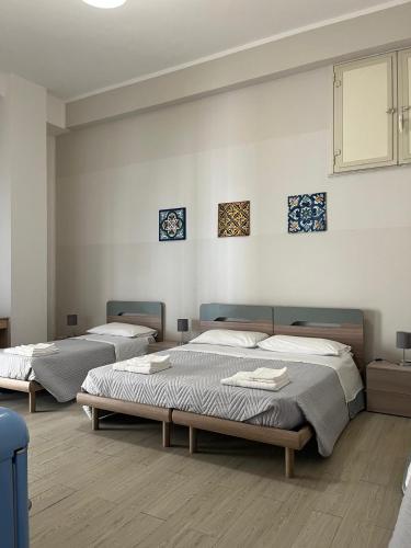 Cette chambre comprend 3 lits. dans l'établissement Gi Gi Affittacamere, à Syracuse