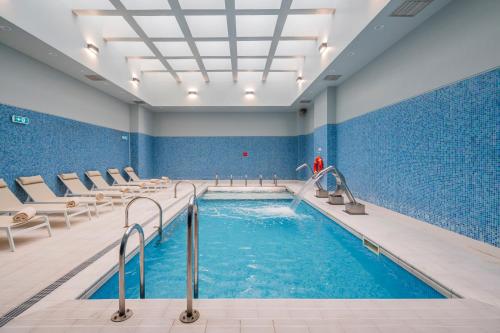 a swimming pool in a building with blue tiles at Gaia Residence in Vila Nova de Gaia