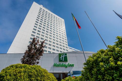 a tall white building with a flag in front of it at Gaia Residence in Vila Nova de Gaia