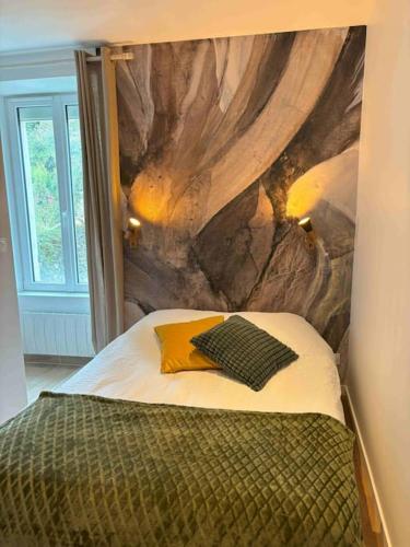 une chambre avec un lit avec un tableau sur le mur dans l'établissement Studio Bois flotté Cherbourg Netflix Parking, à Cherbourg en Cotentin