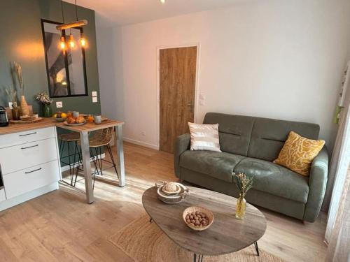 un salon avec un canapé et une table dans l'établissement Studio Bois flotté Cherbourg Netflix Parking, à Cherbourg en Cotentin