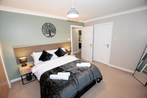 a bedroom with a large bed with a wooden headboard at Bathgate Penthouse near Edinburgh in Bathgate