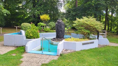 EhlscheidにあるFerienwohnung am Kurpark Ehlscheidの茂みや木々が茂る庭園の像