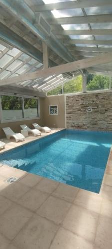 a large swimming pool with white chairs and a blue pool at Complejo Viva Zapata in Mar de las Pampas