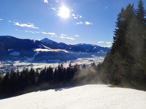 a snow covered mountain with the sun in the sky at Pension Sonnhof in Radstadt