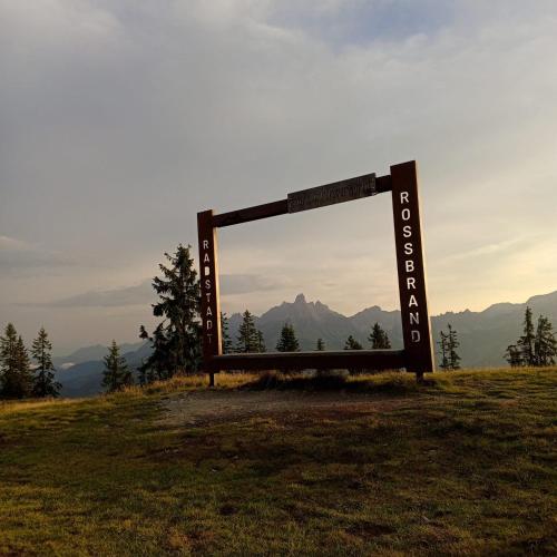 a sign on a hill with mountains in the background at Pension Sonnhof in Radstadt