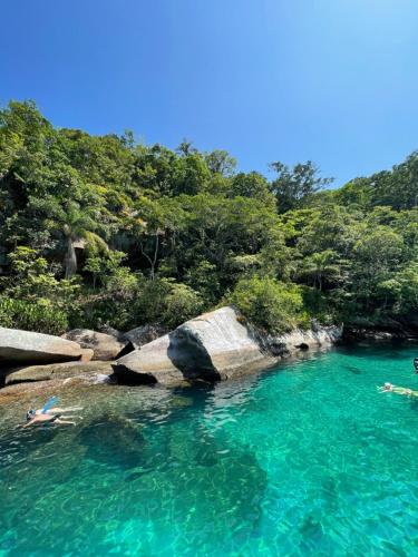 two people swimming in a pool of blue water at Passeio de barco em Paraty in Paraty