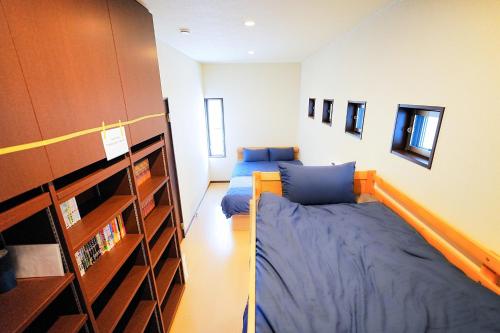 a bedroom with two beds and a book shelf at LOISIR Kunitachi in Kunitachi