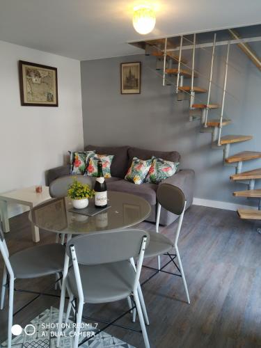 a living room with a couch and a table at Charmant petit logement in Bayeux