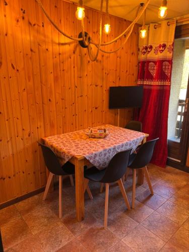 a dining room with a table and some chairs at Cosy Apartment in the Mountain Charme in Montgenèvre