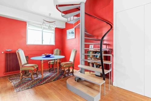 - un escalier en colimaçon dans une chambre avec une table dans l'établissement paris invalides vue Tour Eiffel duplex, à Paris