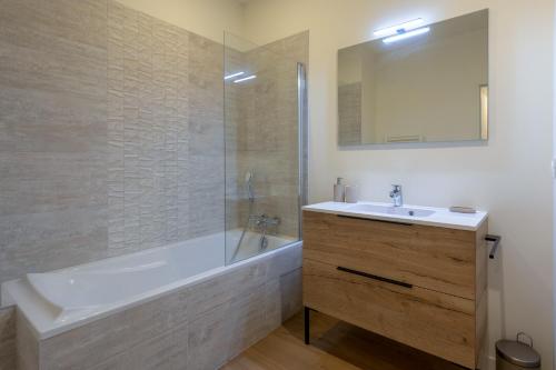 une salle de bain avec une baignoire, un lavabo et un miroir dans l'établissement Sky View, à Toulouse