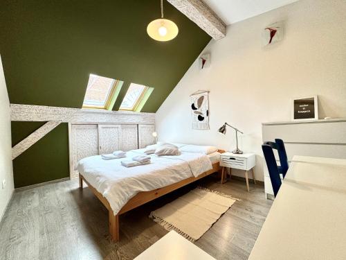 a bedroom with a bed and a green wall at Apartament Old City in Timişoara