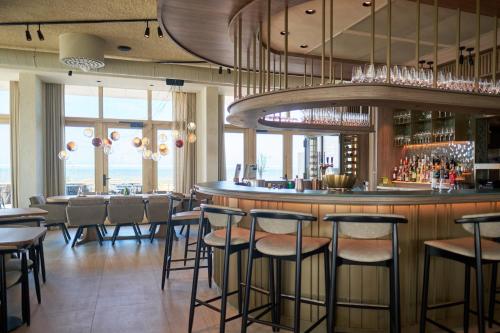 a bar in a restaurant with chairs and tables at Boutique Hotel Blendin Bloemendaal aan Zee in Bloemendaal Aan Zee