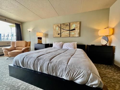 ein Schlafzimmer mit einem großen Bett und einem Stuhl in der Unterkunft Lindell Motor Lodge - Downtown Cedar Falls Studio With Free Gated Parking! in Cedar Falls