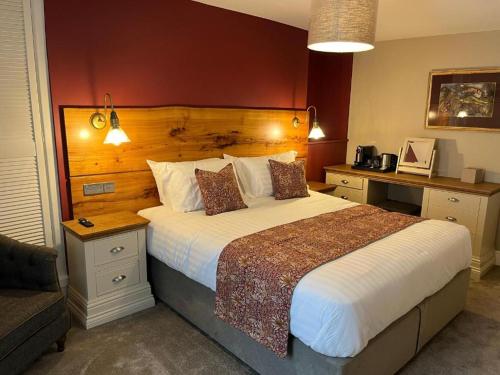 a bedroom with a large bed with a wooden headboard at The Castle Coaching Inn in Trecastle