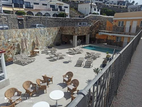 an aerial view of a patio with chairs and a pool at Apartamento en Patalavaca, Granada 1, Arguineguin, Mogán in Patalavaca