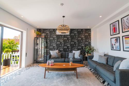 a living room with a couch and a table at 7Min to Uni Sé-Velha - AC - Work Desk - 300MBs WiFi - Suite 4 in Coimbra