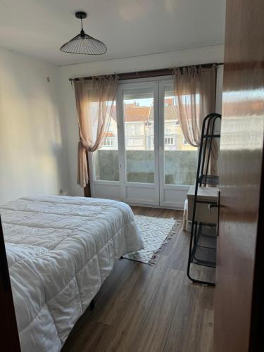 une chambre avec un lit et une grande fenêtre dans l'établissement Elisabeth, à Bray-Dunes