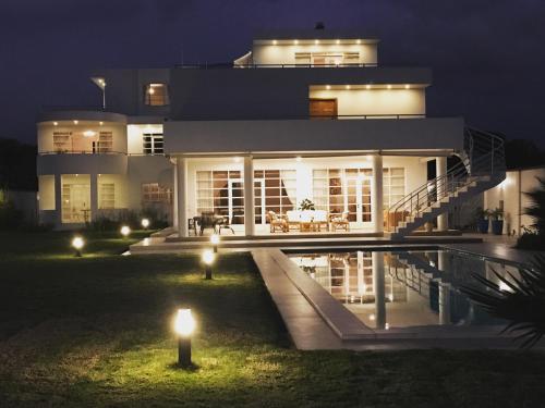a house with a pool in front of it at night at Casa Deco Hotel Boutique in Cochabamba