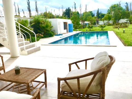 a patio with chairs and a swimming pool at Casa Deco Hotel Boutique in Cochabamba