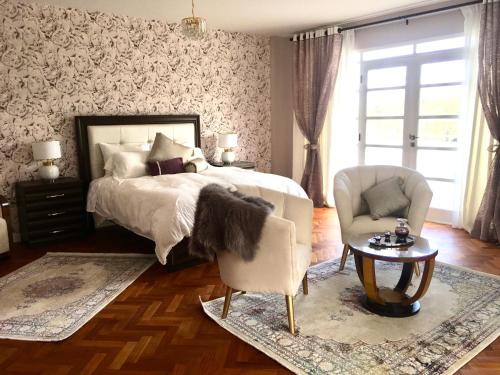 a bedroom with a bed and a chair and a table at Casa Deco Hotel Boutique in Cochabamba