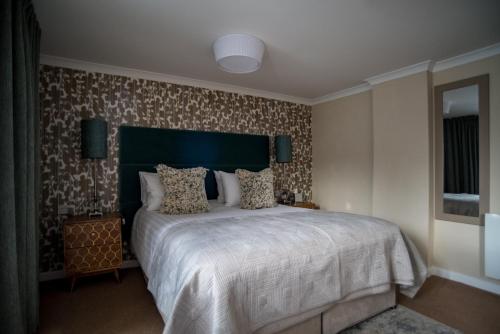 a bedroom with a large bed with a large headboard at Brewers Inn in Cambridge