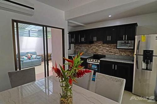 a kitchen with a table with a vase of flowers at 2-BD Unit with Pool 2 Blocks from Beach in Coco