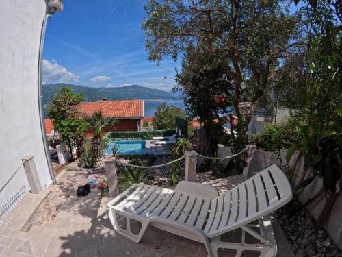 a white bench sitting on a patio next to a pool at Apartments Obradovic in Krasici