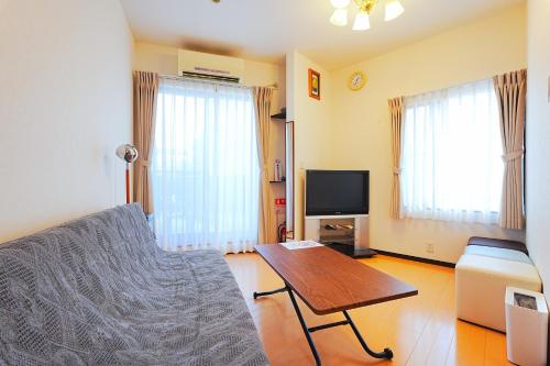 a living room with a couch and a table at LOISIR Kunitachi in Kunitachi
