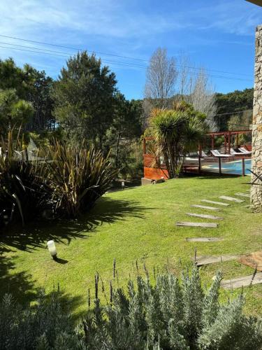 a garden with grass and plants and a fence at Arena de Mar Depto E in Mar de las Pampas