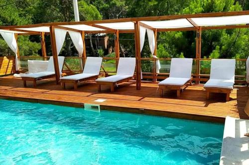 a deck with chairs and a swimming pool at Arena de Mar Depto E in Mar de las Pampas