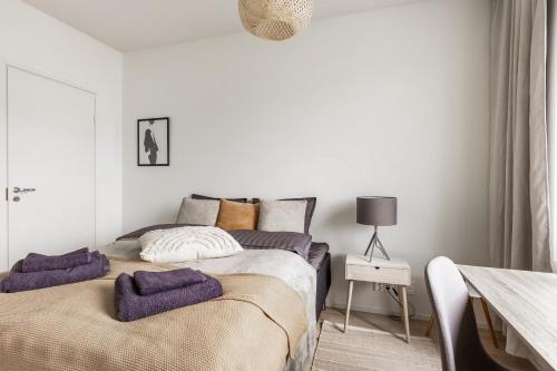 a bedroom with two beds with purple towels on them at Come in! "Harppuuna" Two rooms for two persons next to Turunlinna! in Turku