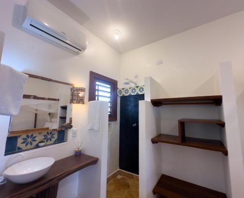 a bathroom with a sink and a mirror at Exclusive House Preá in Cruz