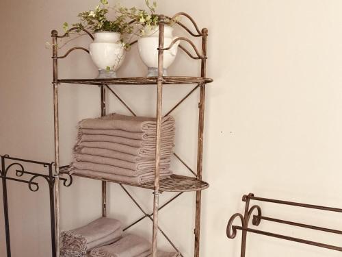a towel rack with two vases and towels on it at Le Moulin Neuf in Saint-Antoine-Cumond