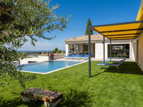 une arrière-cour avec une piscine et un auvent jaune dans l'établissement Borie, à Beaumes-de-Venise