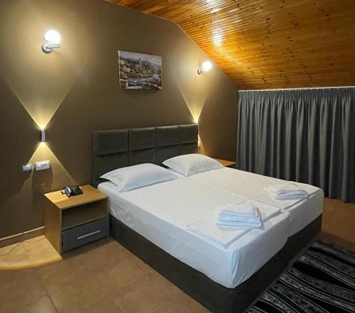 a bedroom with a large bed with white sheets at Hotel Milano in Tirana