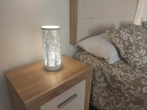 a lamp on a night stand next to a bed at gomera view experience in Callao Salvaje