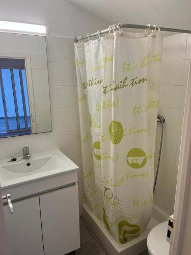 a bathroom with a shower curtain and a sink at Casa 18 in Évora