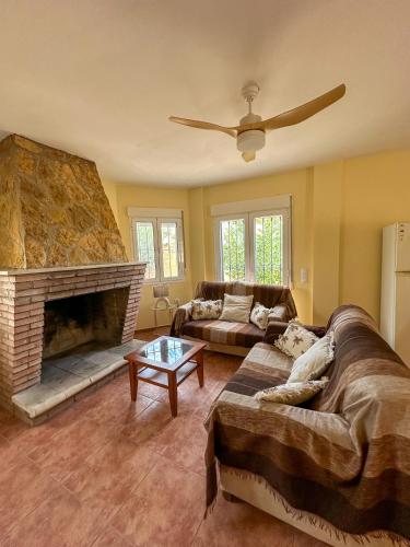 a living room with two couches and a fireplace at Casa Rural El Pomelo in Zurgena