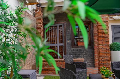 a brick house with a door and chairs in front at R-HOME Li Cuti in Catania