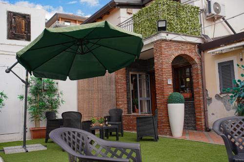 a green umbrella sitting on top of a yard at R-HOME Li Cuti in Catania