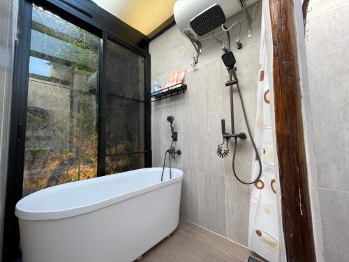 a bath tub in a bathroom with a window at Waiting for the Blossoms B&B Tea House in Shantou
